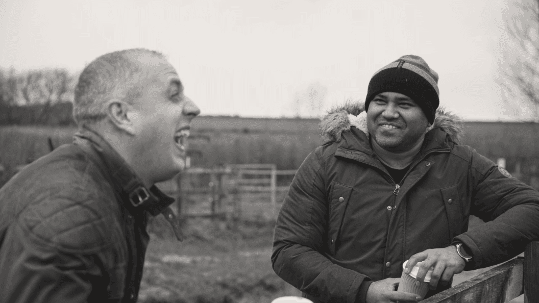 Two young men sharing a laugh while out walking in the country