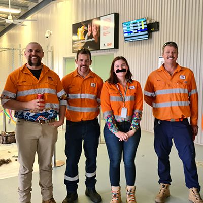 Miners in high-vis safety gear, smiling to camera and wearing excellent moustaches.