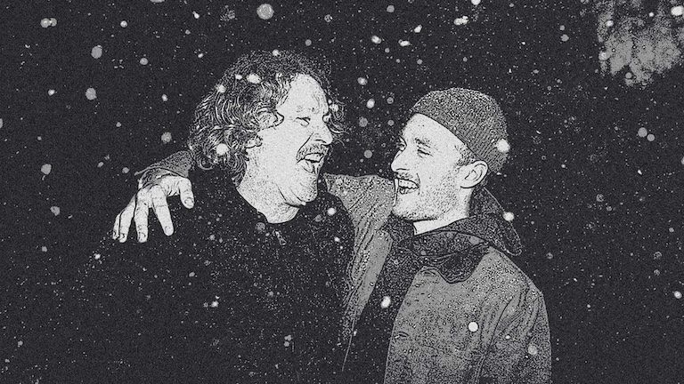 Photo of two men embracing in the snow.