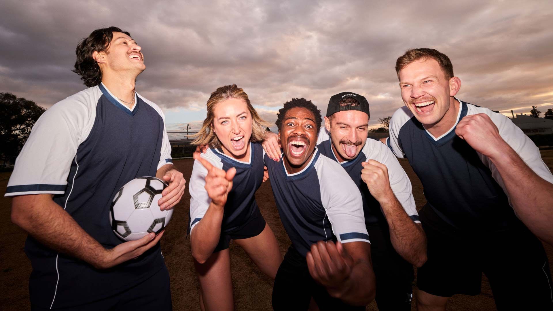 Photo of a sports team cheering to camera.