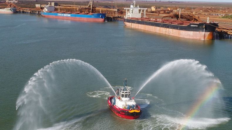 Photo of commercial tug boat on the water, near a mining site.