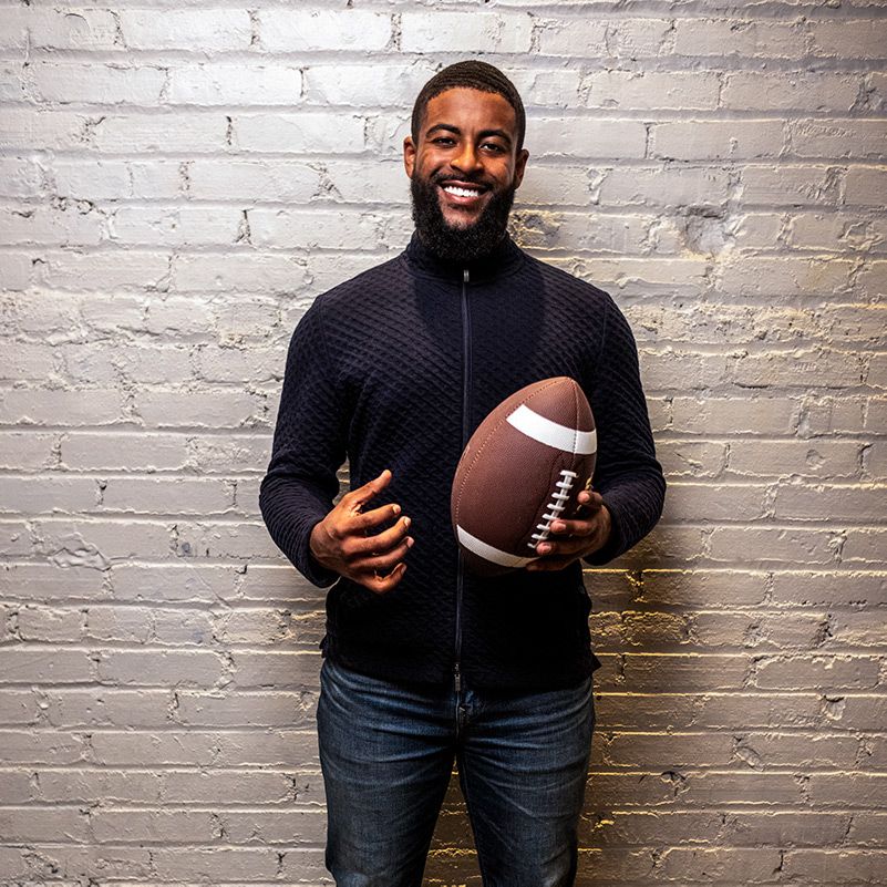 Portrait photo of Chase Griffin, UCLA Bruins quarterback, smiling to camera and holding a football.