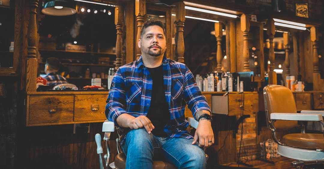 Un homme moustachu pose pour son portrait dans un salon de barbier