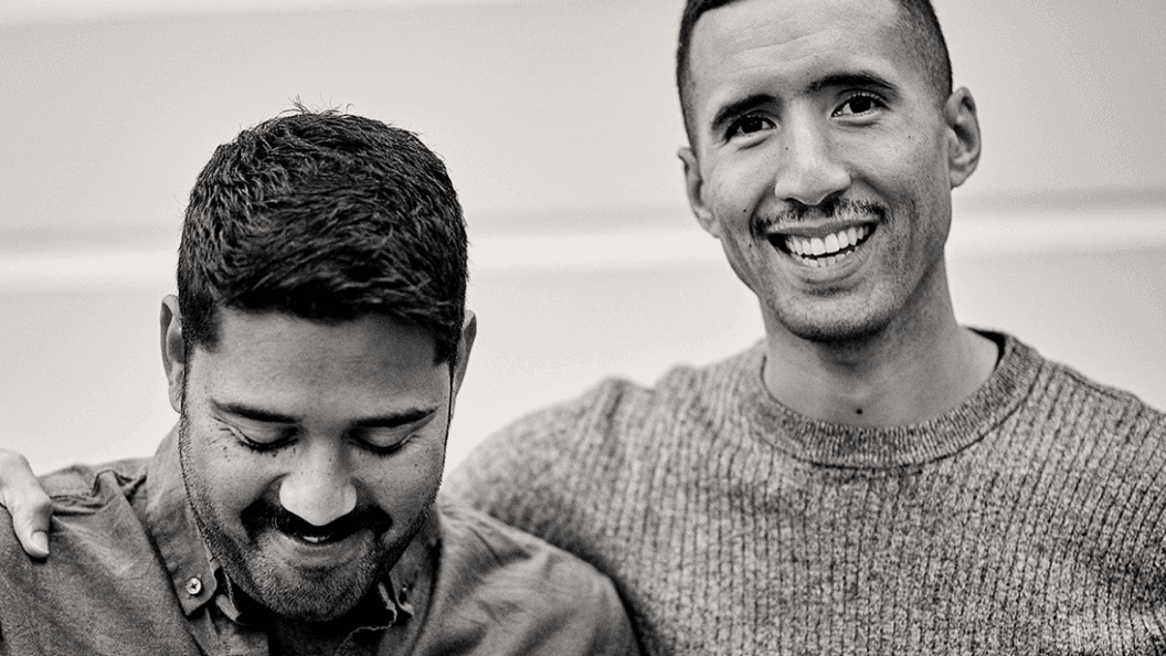 Two men smiling into camera