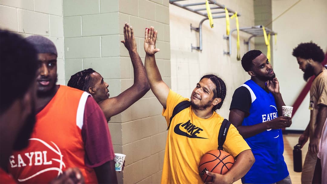 A group of young men high fiving in a locker room