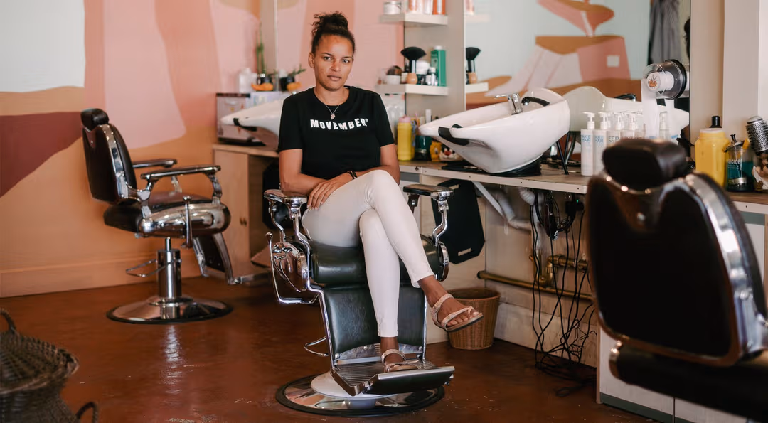 Mo Sister Sheila in a barber chair.