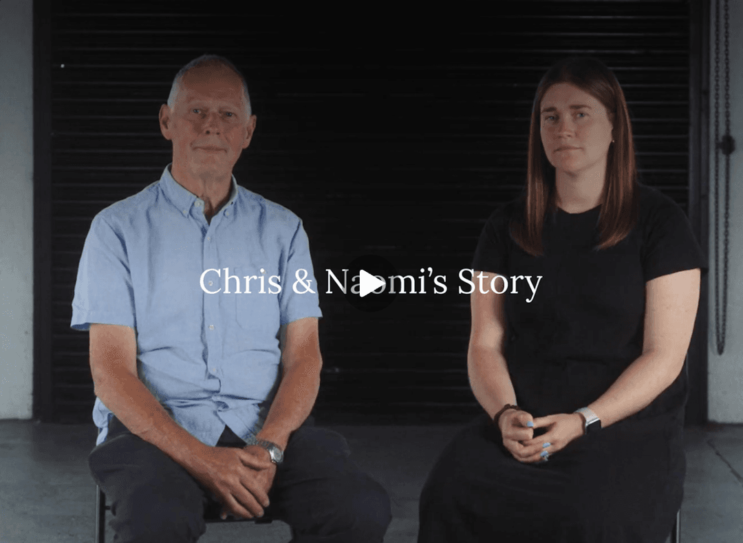 Chris and Naomi sit on chairs facing the camera, ready for a documentary style interview