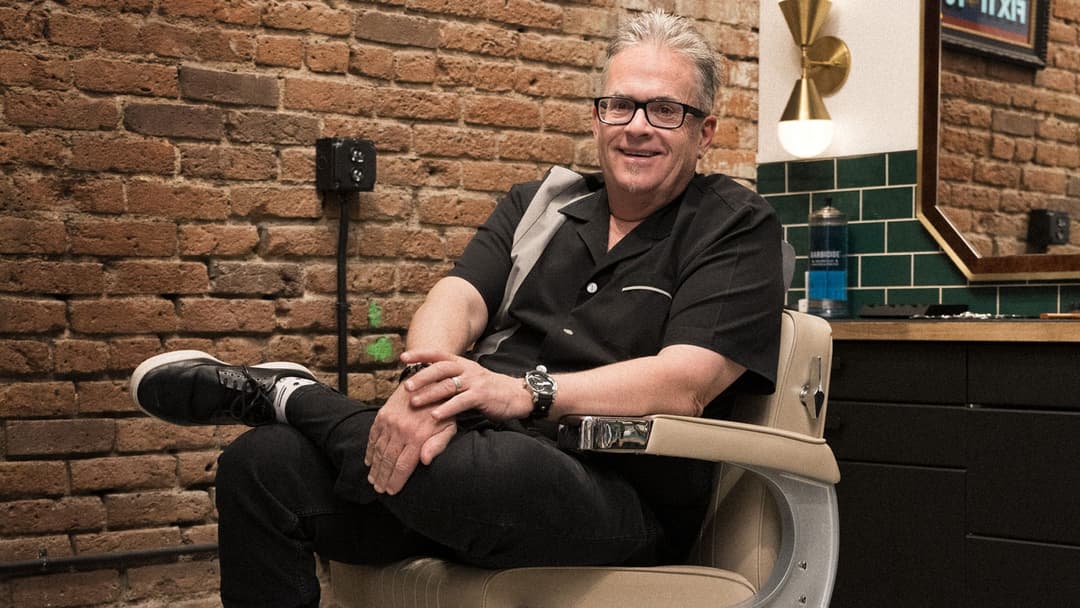 Mo Bro Jeff smiles for the camera from a classic barbershop chair in Denver