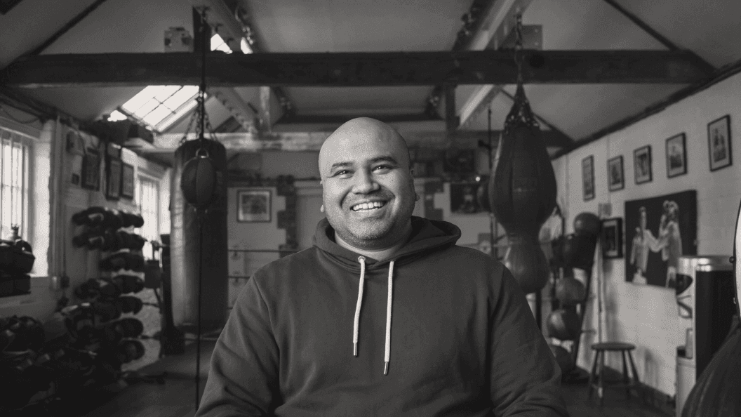 Man sitting inside a boxing gym
