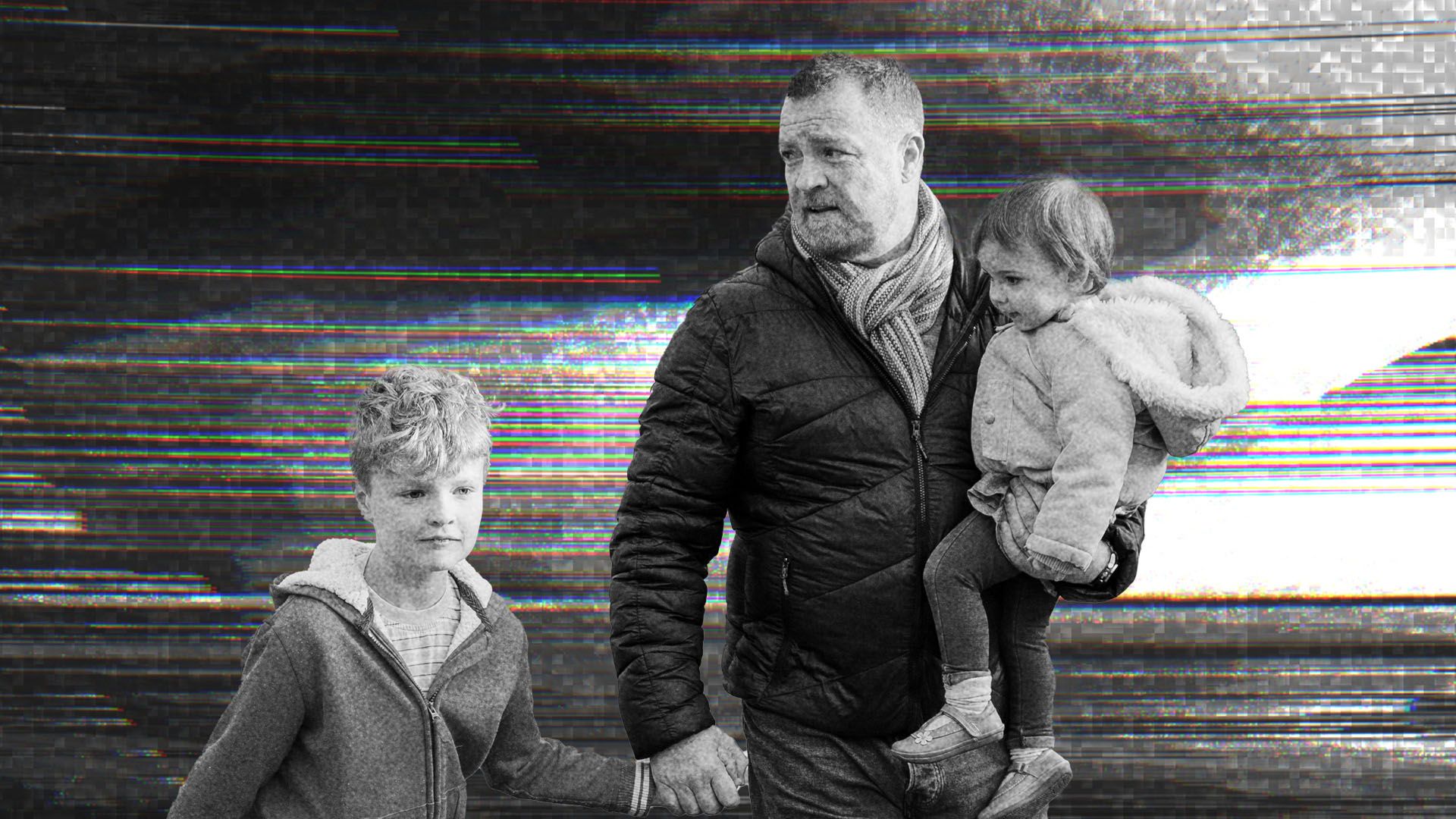 A father walking with his two children.