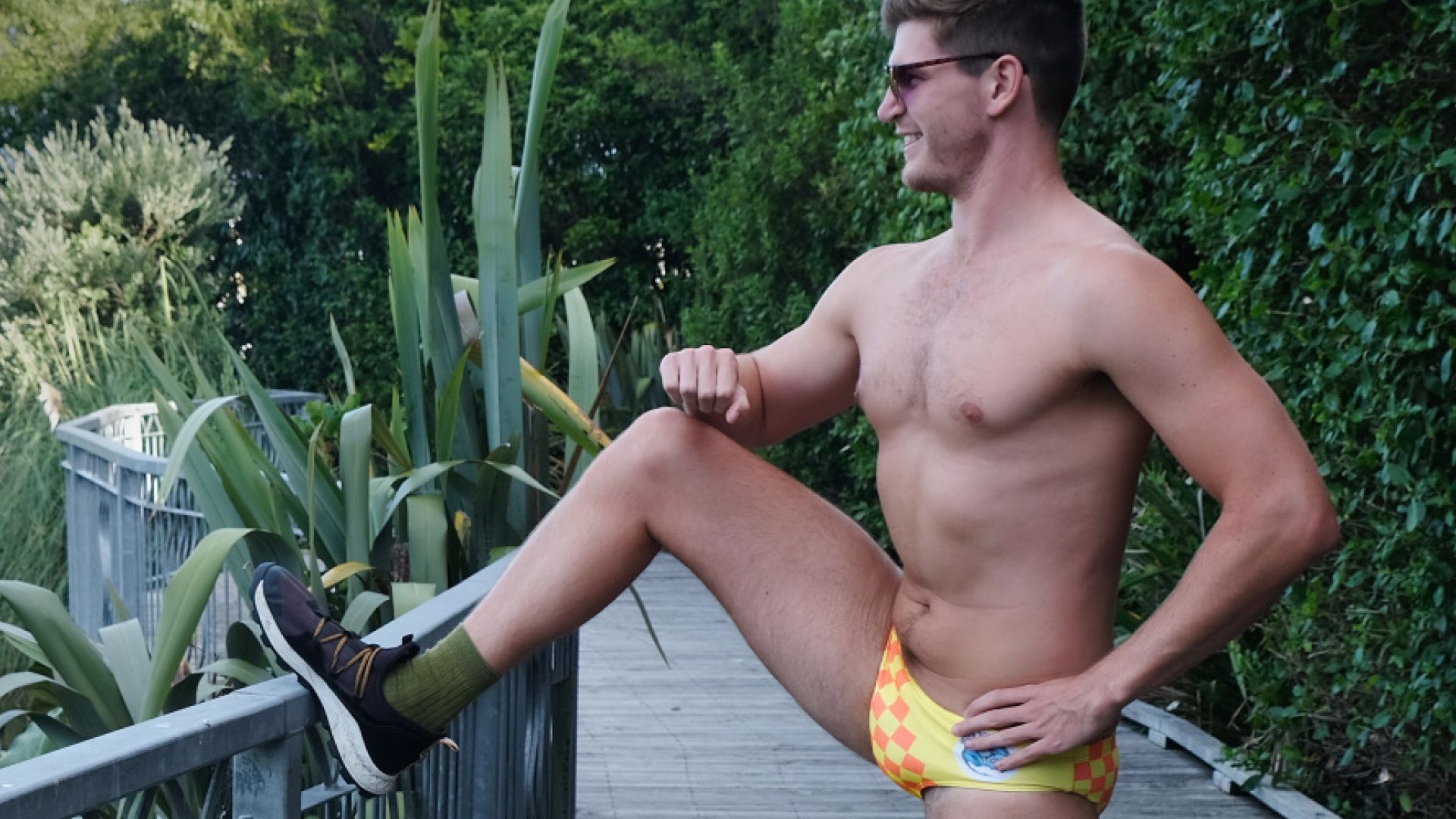 A man in Speedo's stretching before a run.
