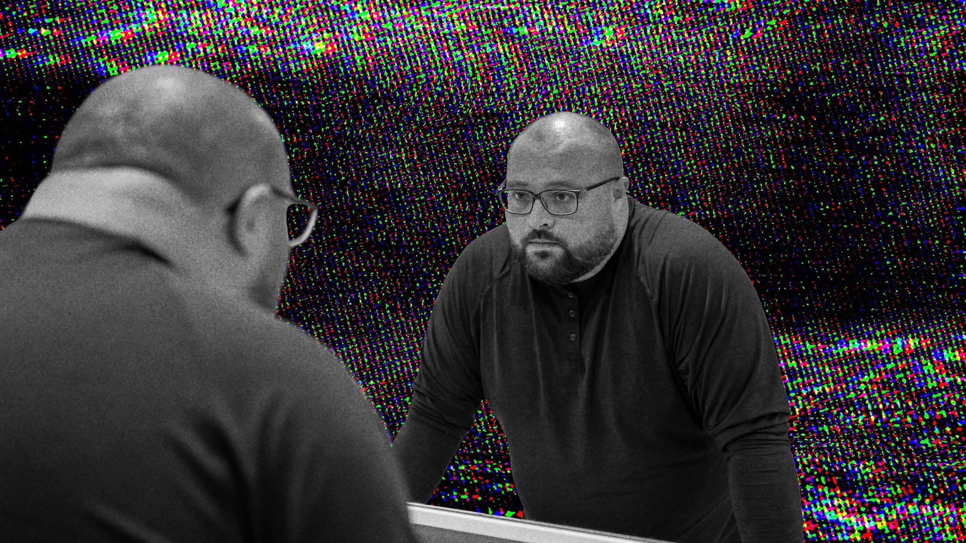 A man looking at himself in the mirror.